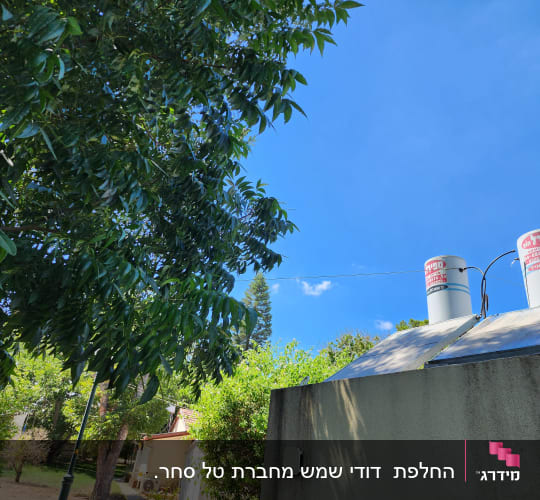 דודי שמש על גג עם שמיים כחולים ועצים ברקע